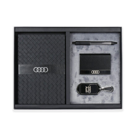 A box containing A5 softcover notebook, a metal pen, cardholder and a keychain.